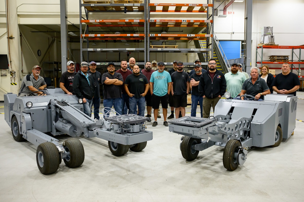 Members of the 526th EMXS pose for a group photo behind the MJ-1 and MHU-83 lift trucks.