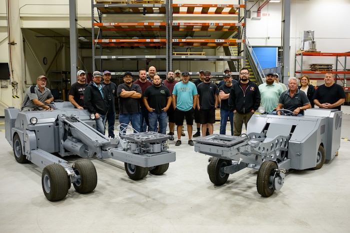 Members of the 526th EMXS pose for a group photo behind the MJ-1 and MHU-83 lift trucks.