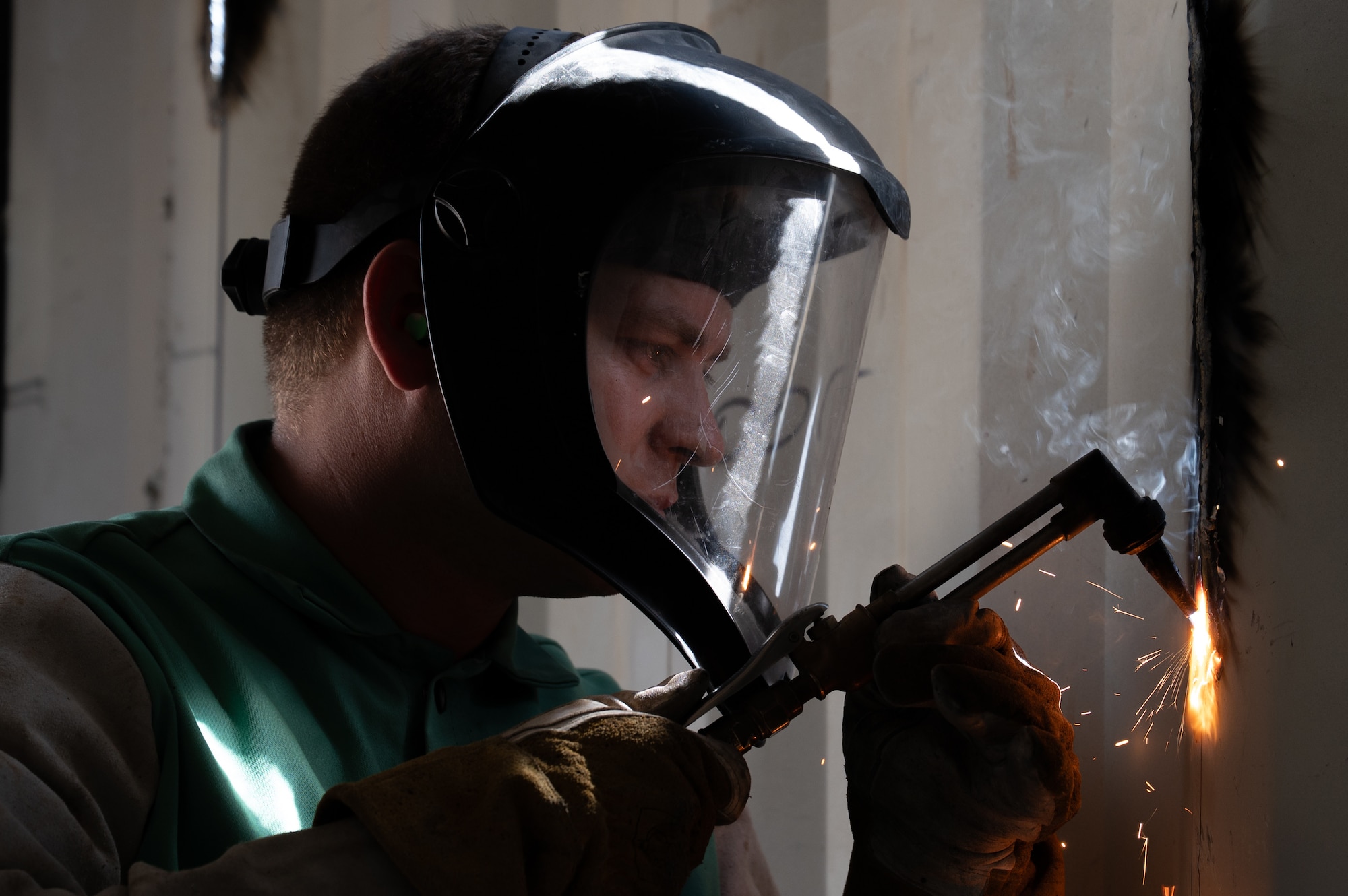 Service member cuts metal with torch