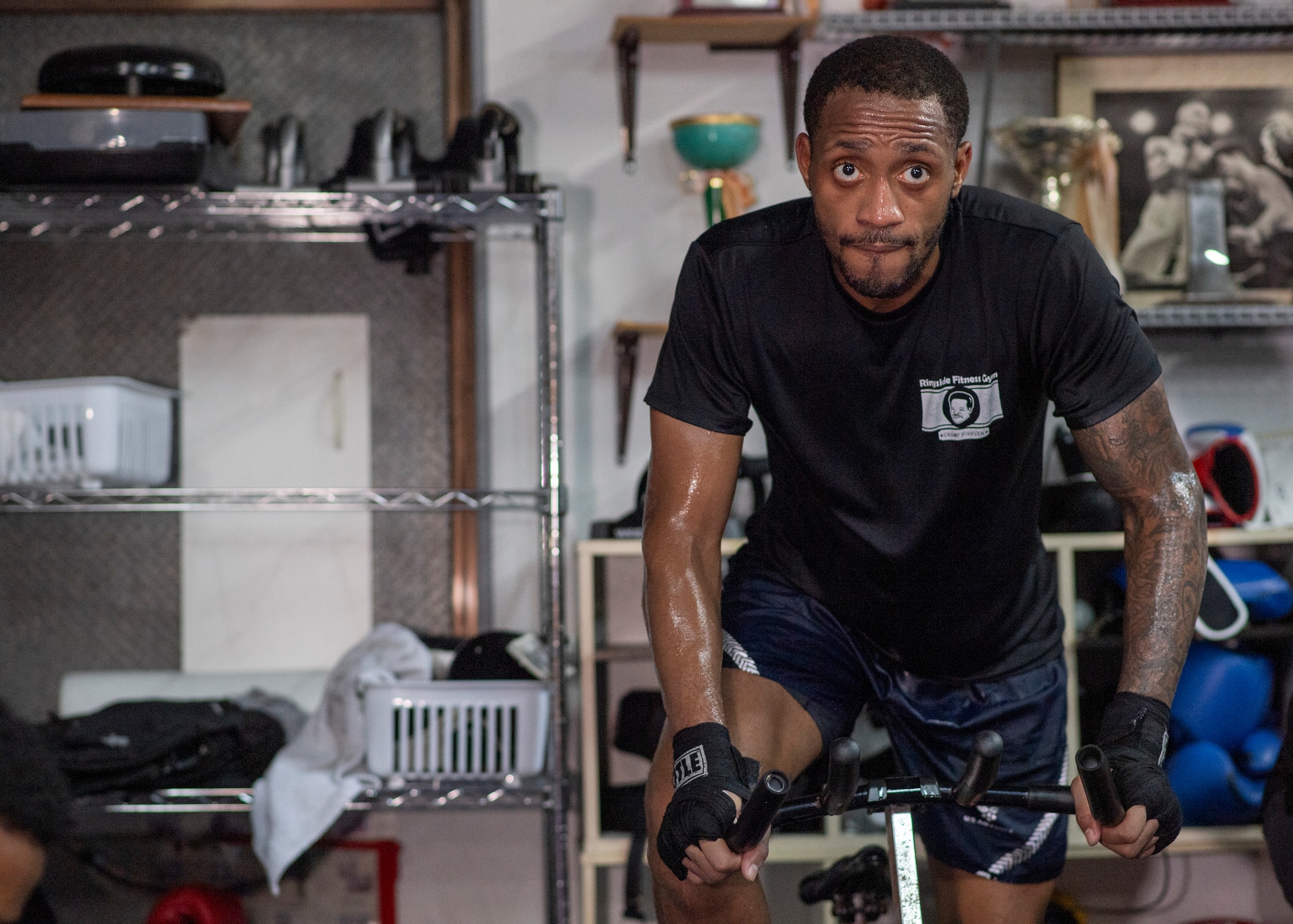 U.S. Air Force Senior Airman Craig Jeudy, Fifth Air Force technical support technician, rides a stationary bike during a training session.