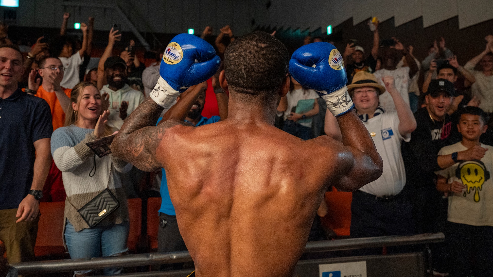 U.S. Air Force Senior Airman Craig Jeudy, Fifth Air Force technical support technician, receives cheers after winning his second professional boxing match.
