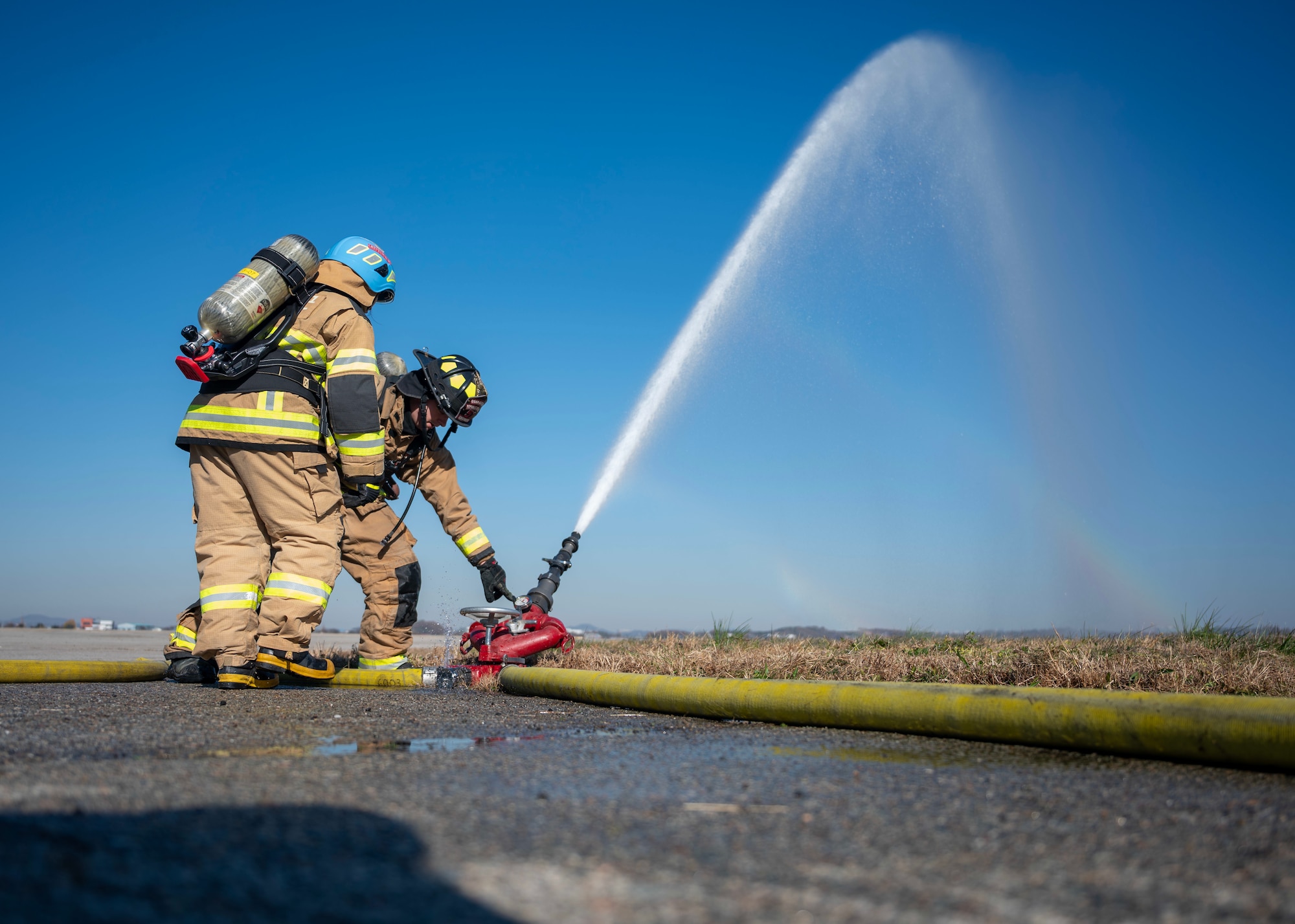 U.S. Air Force Senior Airman Michael Russell, 51st Civil Engineer Squadron firefighter, explains the 1410 drill to a Republic of Korea Air Force firefighter at Osan Air Base, Republic of Korea, Nov. 21, 2025. A 1410 drill is a hose deployment drill used across Air Force fire departments to practice getting water on a target quickly while the fire truck is still in motion, emphasizing communication, speed and teamwork. (U.S. Air Force photo by Staff Sgt. Sarah Williams)