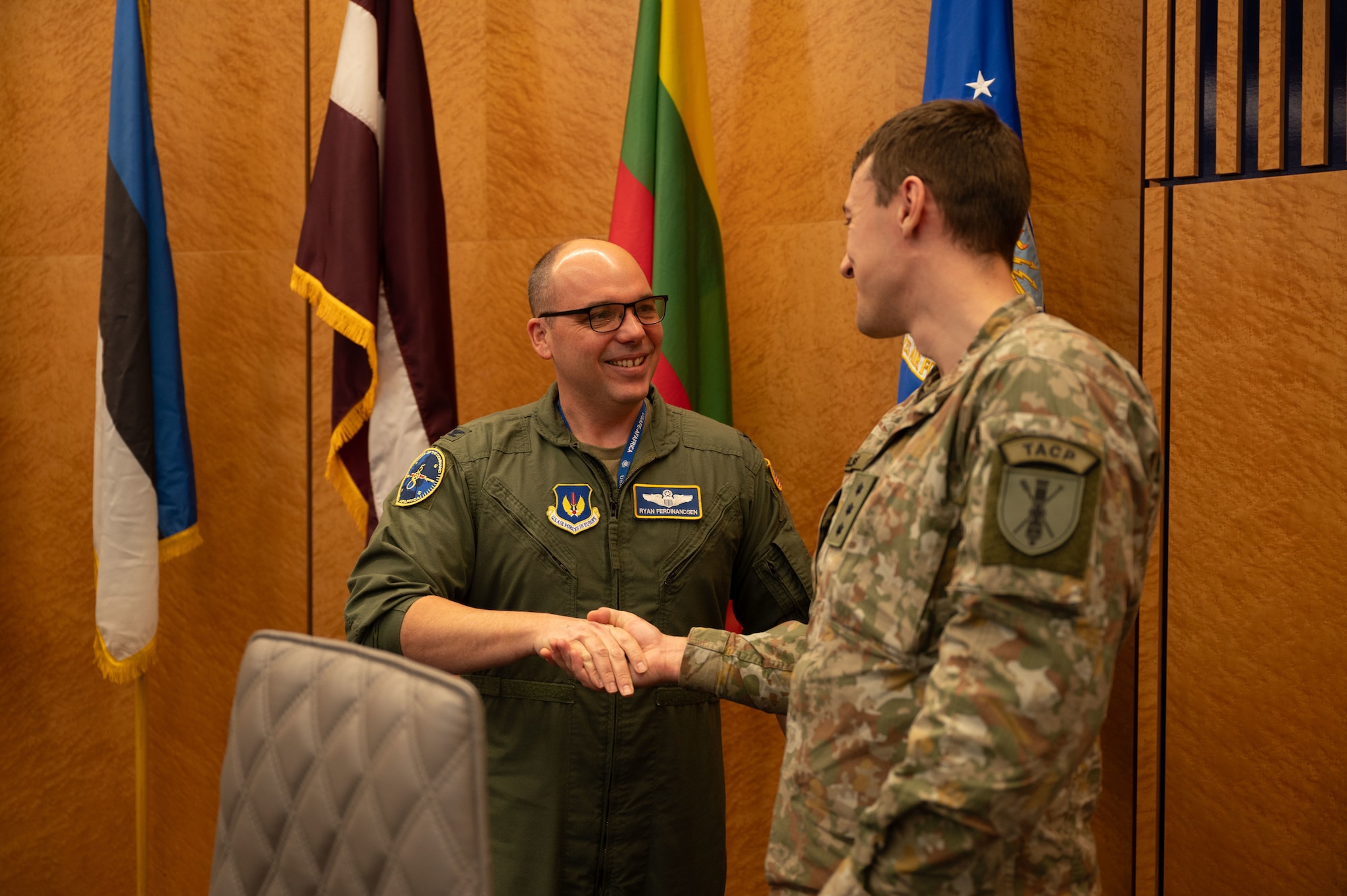 U.S. Air Force Col. Ryan Ferdinandsen, left, U.S. Air Forces in Europe - Air Forces Africa deputy director of plans and programs, receives a challenge coin from Lithuanian Air Force Captain Andrius Juozelskis, during a visit at the USAFE-AFAFRICA Headquarters at Ramstein Air Base, Germany, Nov. 25, 2025.