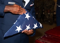 A photo of an Airman holding the U.S. flag.