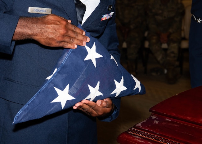 A photo of an Airman holding the U.S. flag.