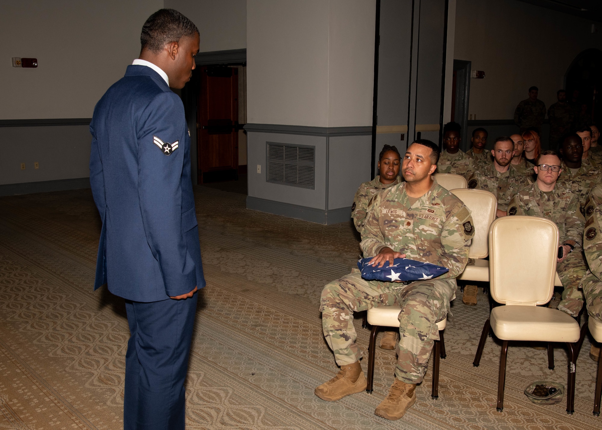A photo of an Airman presenting the flag during a pallbearer ceremony demonstration.