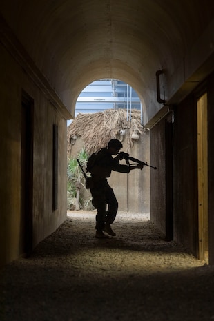 U.S. Marine Corps Pfc. Keegan Farmer, an expeditionary fuels technician with Combat Logistics Battalion 2, Combat Logistics Regiment 2, 2nd Marine Logistics Group, clears rooms in an alleyway at the Infantry Immersion Trainer at Marine Corps Base Camp Lejeune, North Carolina, Nov. 21, 2025. The IIT is a facility which provides an urban training environment for Marines and Sailors, aiding in increasing combat efficiency by training in realistic conditions. Farmer is a native of Mississippi. (U.S. Marine Corps photo by Lance Cpl. Isabella Ramos)