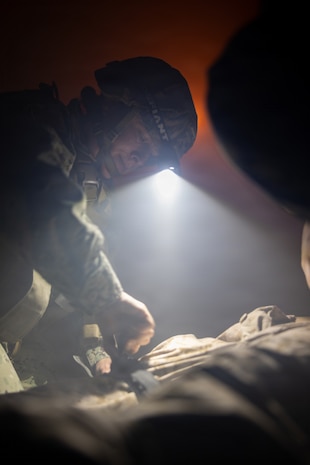 U.S. Navy Lt. Lisa Talledo, a medical officer with 2nd Medical Battalion, 2nd Marine Logistics Group, applies a tourniquet to a simulated casualty during the culminating event of a Tier IV Tactical Combat Casualty Care course at Marine Corps Base Camp Lejeune, North Carolina, Oct. 8, 2025. 2nd MLG became the first-ever Marine Corps command to host a Tier IV TCCC course and is now hosting its second iteration. The course trains select military service members to become proficient combat paramedics capable of providing advanced casualty care at the point of injury on the battlefield and in austere environments. (U.S. Marine Corps photo by Lance Cpl. Brady V. Hathaway)