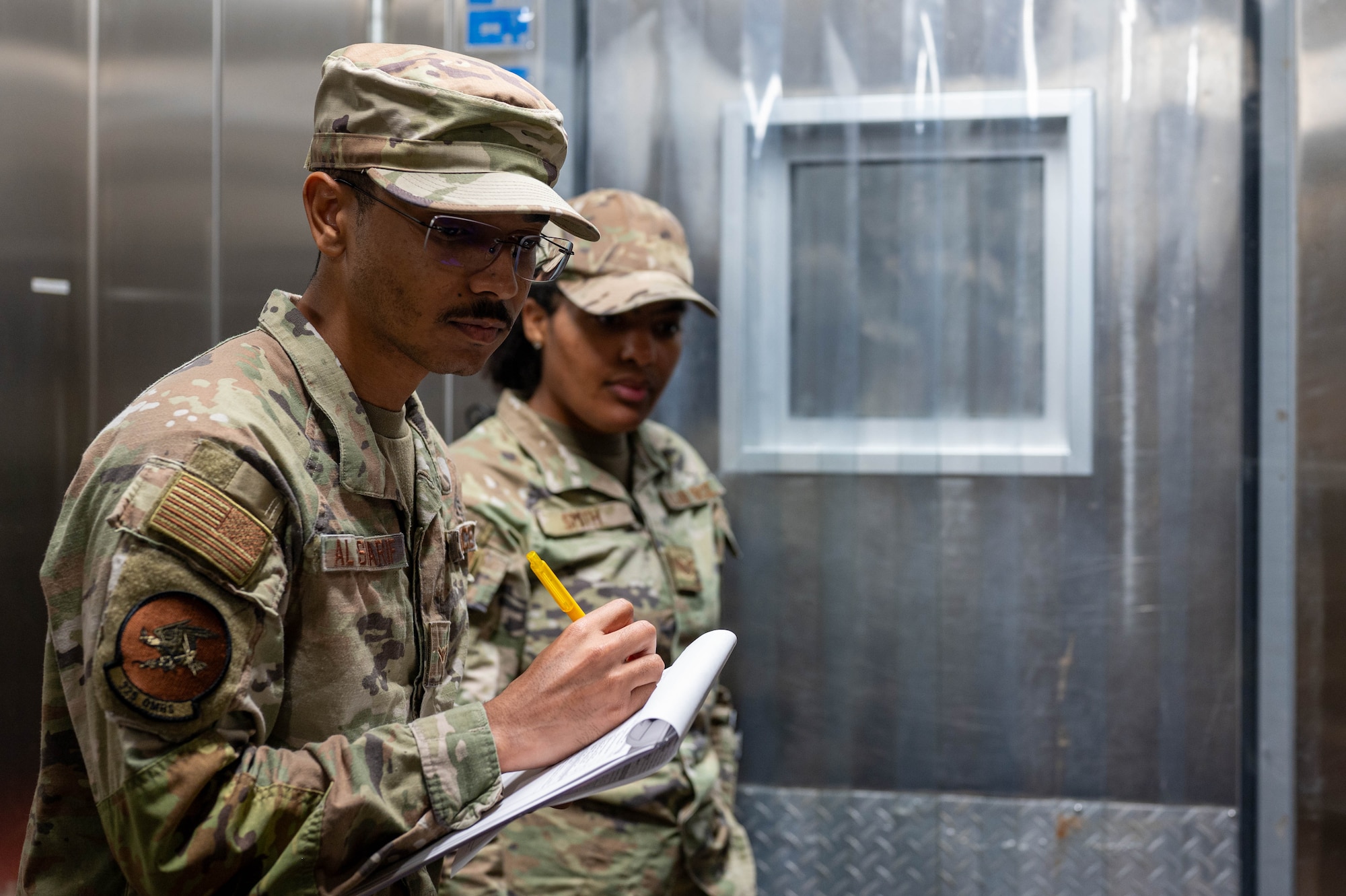 U.S. Air Force Airman Abdulhayy Al-Sharif, 325th Operational Medical Readiness Squadron public health technician and Staff Sgt. Jessica Smith, 325th Force Support Squadron production manager, inspect freezer temperatures during a routine food safety inspection at the dining facility on Tyndall Air Force Base.