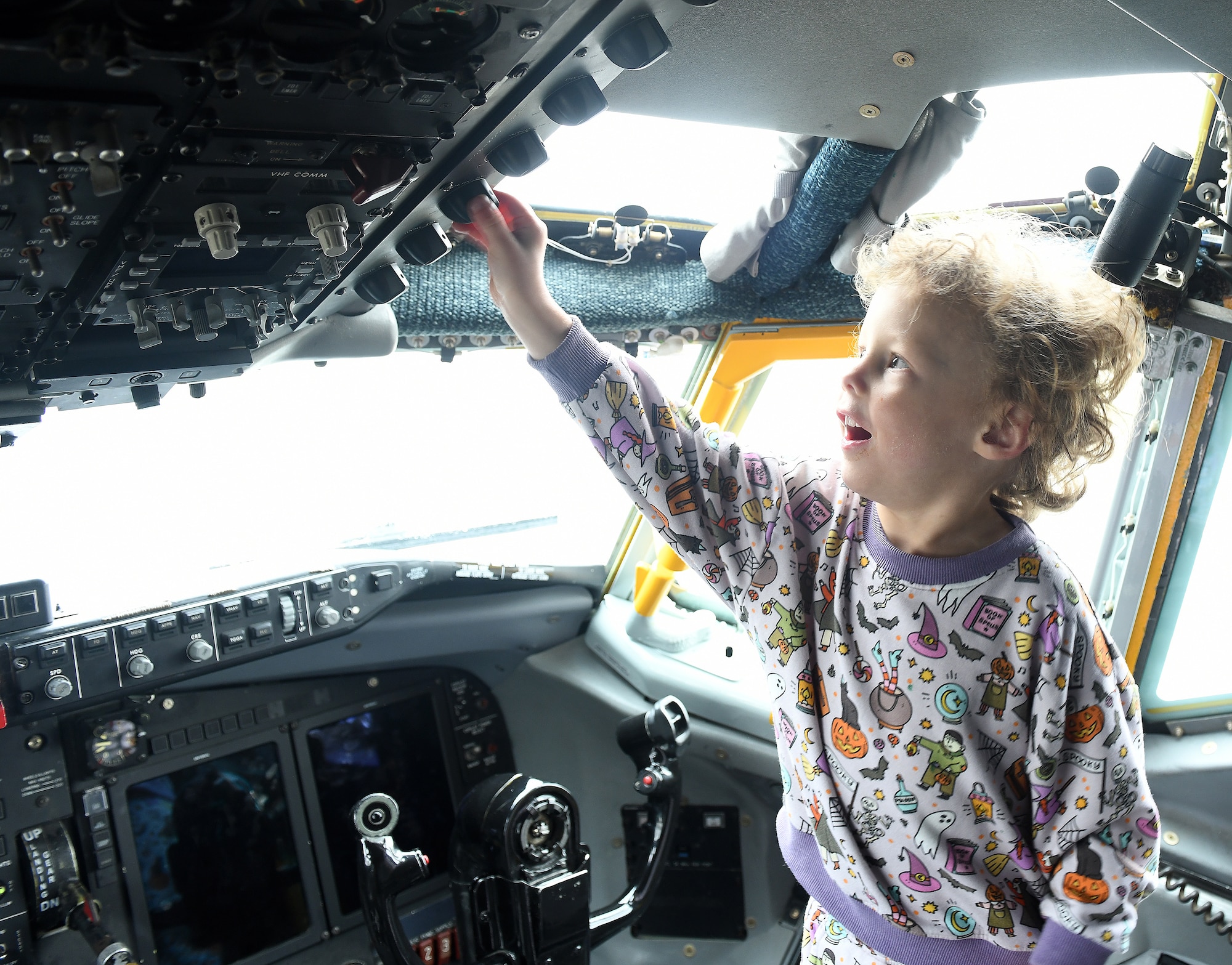 A boy touches a nob inside a RC-135 Rivet Joint aircraft