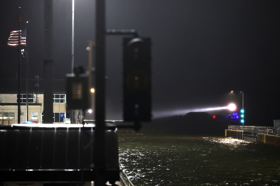 Tow boat enters Lock and Dam 2 on the Mississippi River at night.