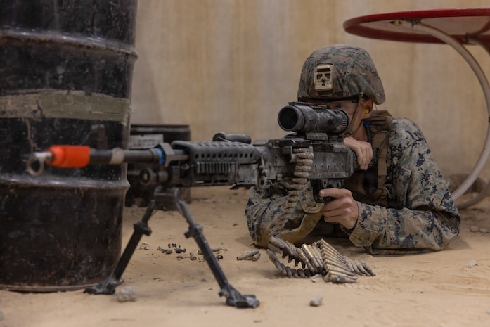 U.S. Marine Corps Lance Cpl. Ryan Knobloch, a satellite transmissions system operator with Communications Company, Headquarters and Service Battalion, 2nd Marine Logistics Group, posts security with an M240B machine gun at the Infantry Immersion Trainer at Marine Corps Base Camp Lejeune, North Carolina, Nov. 18, 2025. The Infantry Immersion Trainer is a facility which provides an urban training environment to Marines and Sailors, aiding in increasing combat efficiency by training in realistic conditions. Knobloch is a native of Illinois. (U.S. Marine Corps photo by Lance Cpl. Isabelle Veillette)