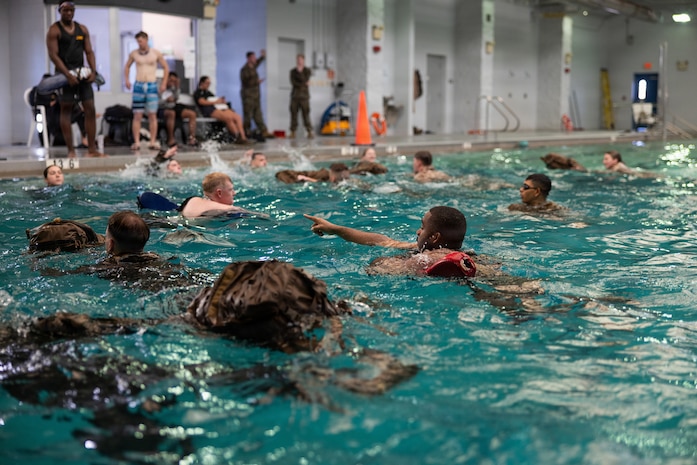 U.S. Marines with 2nd Combat Readiness Regiment, 2nd Marine Logistics Group, conduct swim rescue techniques during a water survival advanced course at Marine Corps Base Camp Lejeune, North Carolina, Nov. 20, 2025. Marine Corps instructors in water survival taught 2nd MLG Marines advanced techniques in case of a man overboard, shipwreck or rescue situation while at sea. (U.S. Marine Corps photo by Lance Cpl. Talan Werner)
