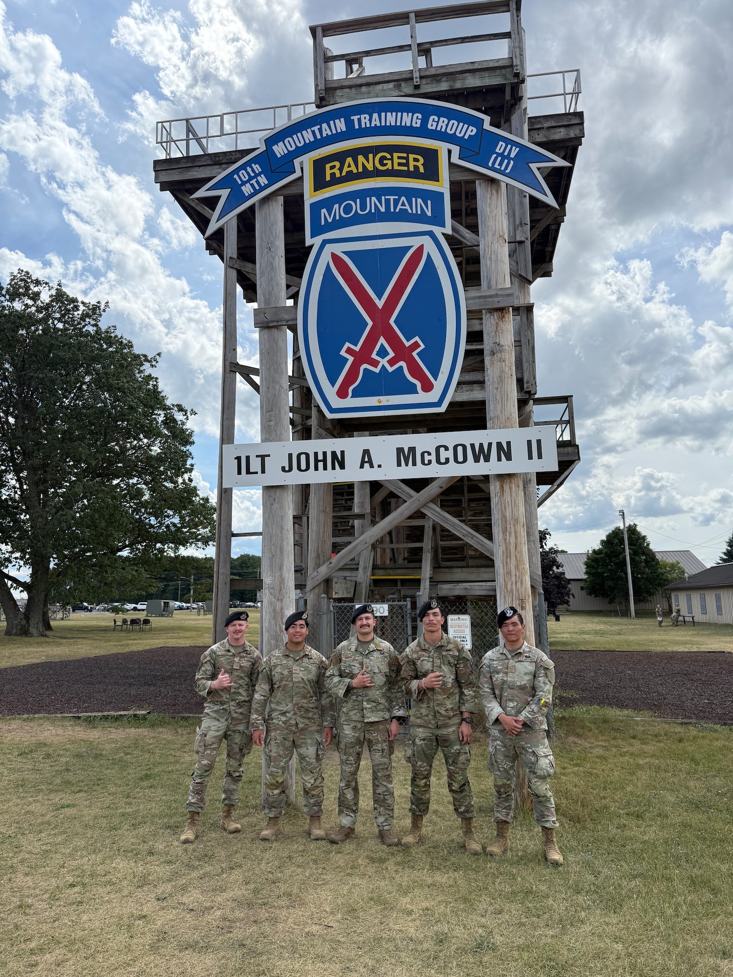 Group of defenders from the 21SFS stand together in front of a rapelling tower.
