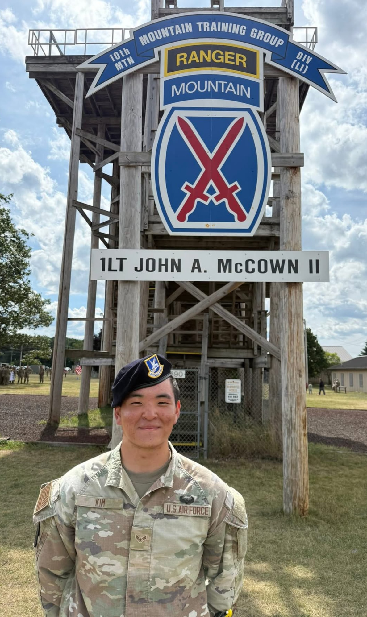 Kim stands in front of a rapelling tower.