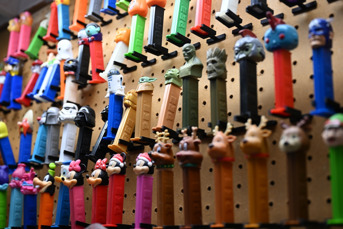 Pez dispensers lined against a wall for a collection.