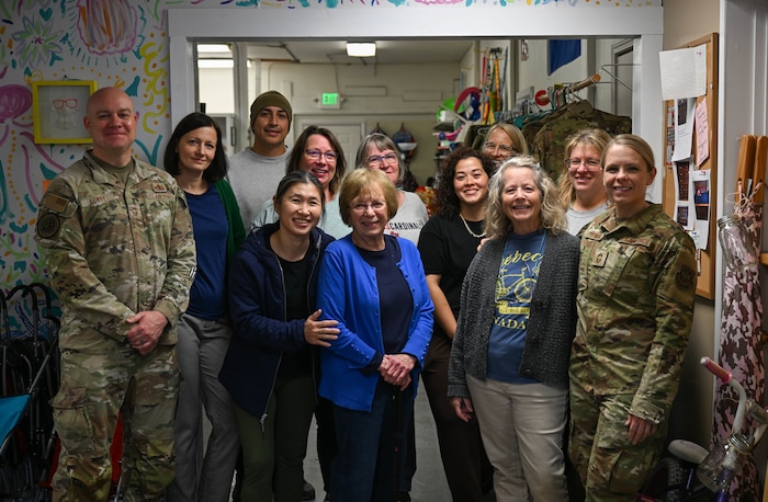 Group of people stand together for a photo.