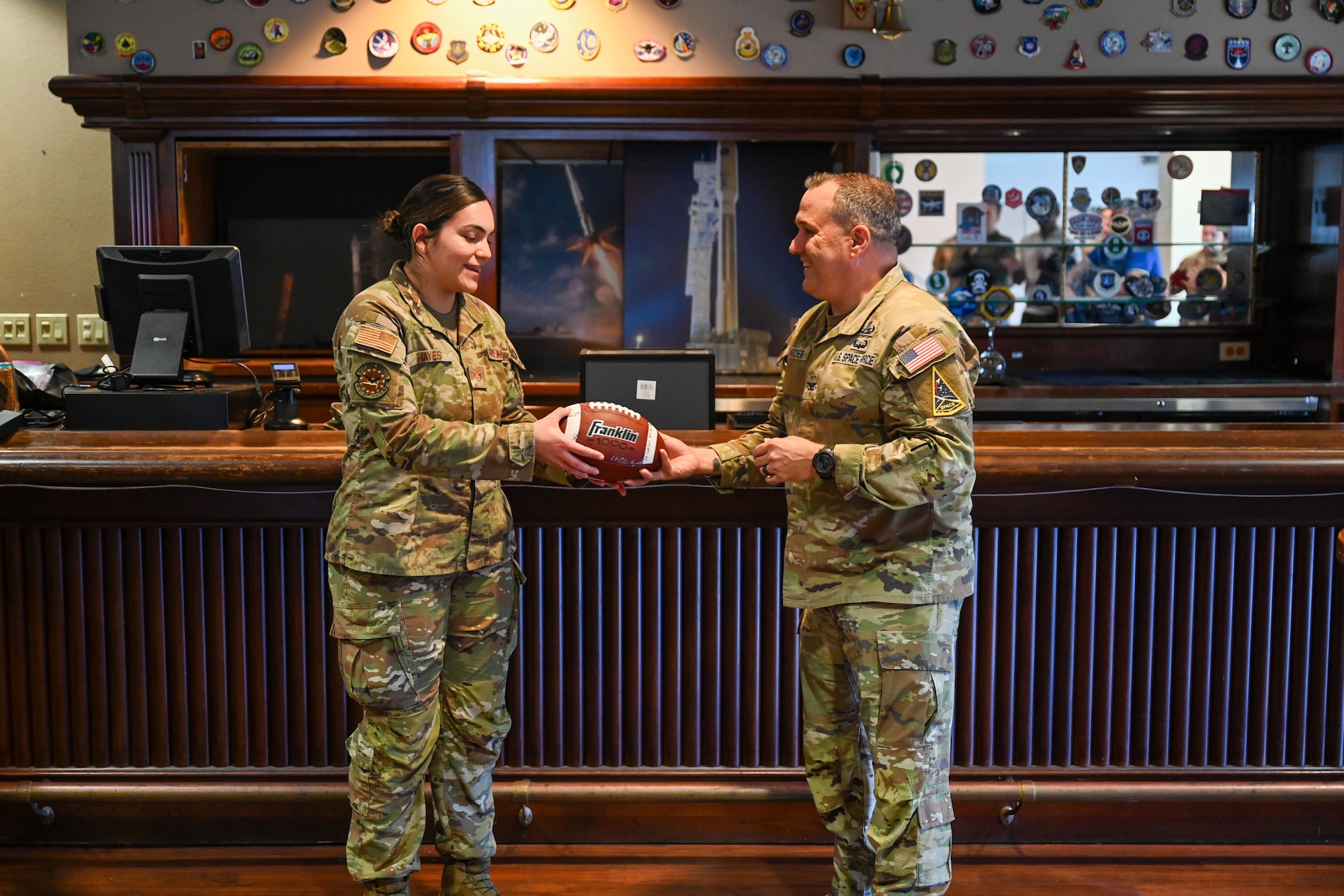 People stand holding a football.