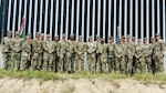 Soldiers from the 168th Military Police Battalion pose for a photograph at the U.S. Southern Border during their deployment supporting the U.S. Border Patrol in the Rio Grande Valley Sector near Edinburg, Texas—photo by the Tennessee National Guard.