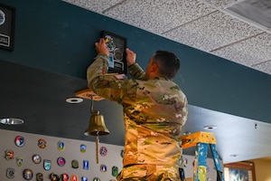 A person hangs a frame.