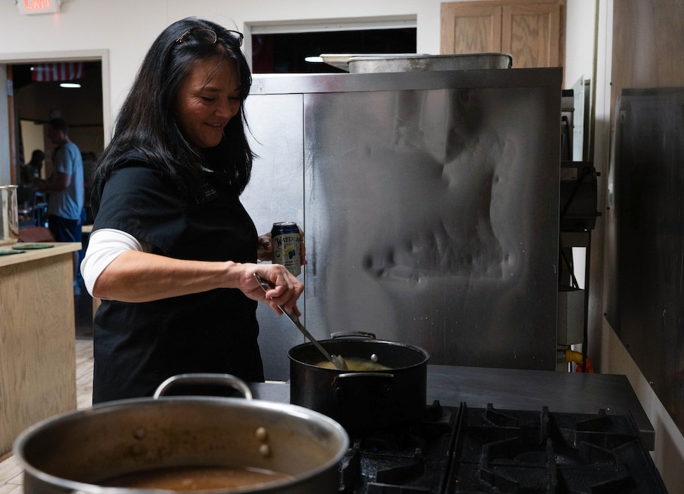 Nicole Elliott, honorary commander and director of Zero Suicide Services, helps prepare Thanksgiving dinner at the Crossroads Student Ministry Center at Goodfellow Air Force Base, Texas, Nov. 21, 2025. Every year, Goodfellow leadership and the community come together to prepare a Thanksgiving dinner for base students. (U.S. Air Force photo by Airman 1st Class Maria Mota)
