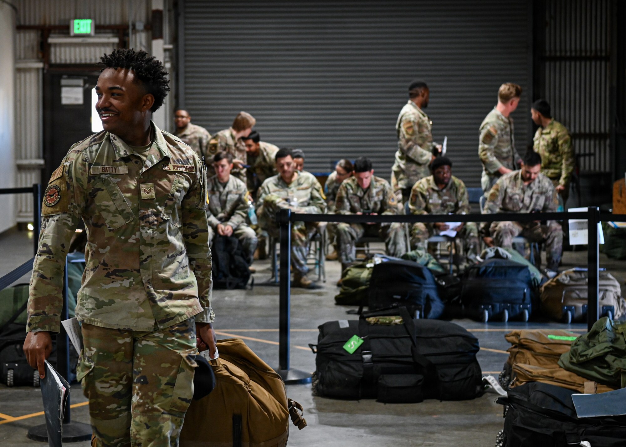 An Airman walks away from his group of fellow deployment returnees in order to return his gear and equipment for check-in.