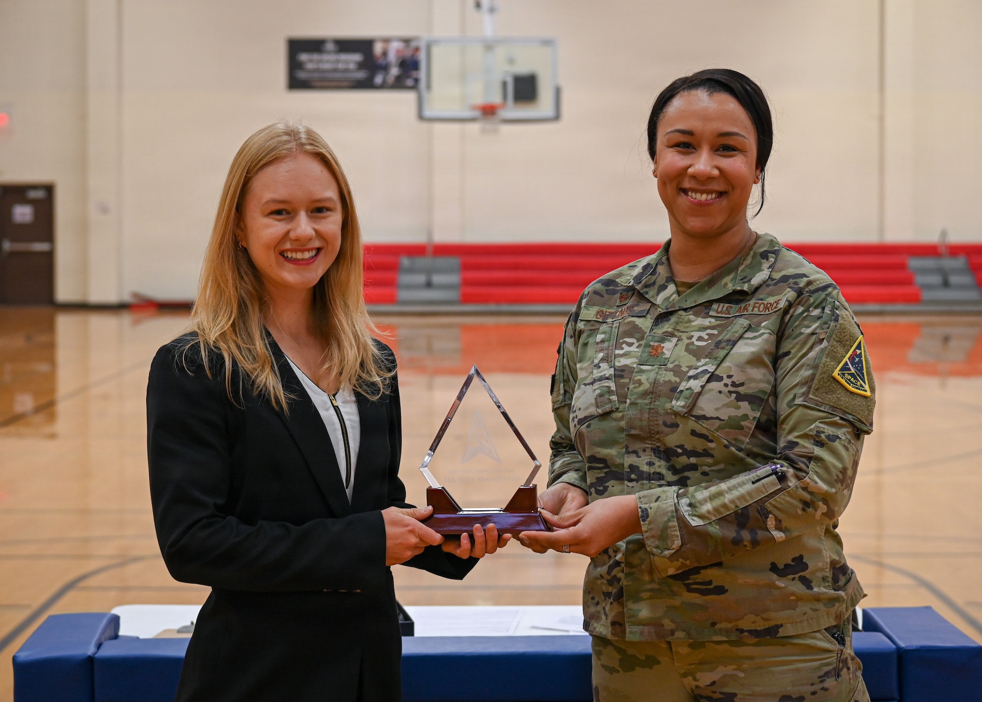 The Vandenberg female athlete of the year for 2025 poses with her new award next to the 30th Force Support Squadron commander.
