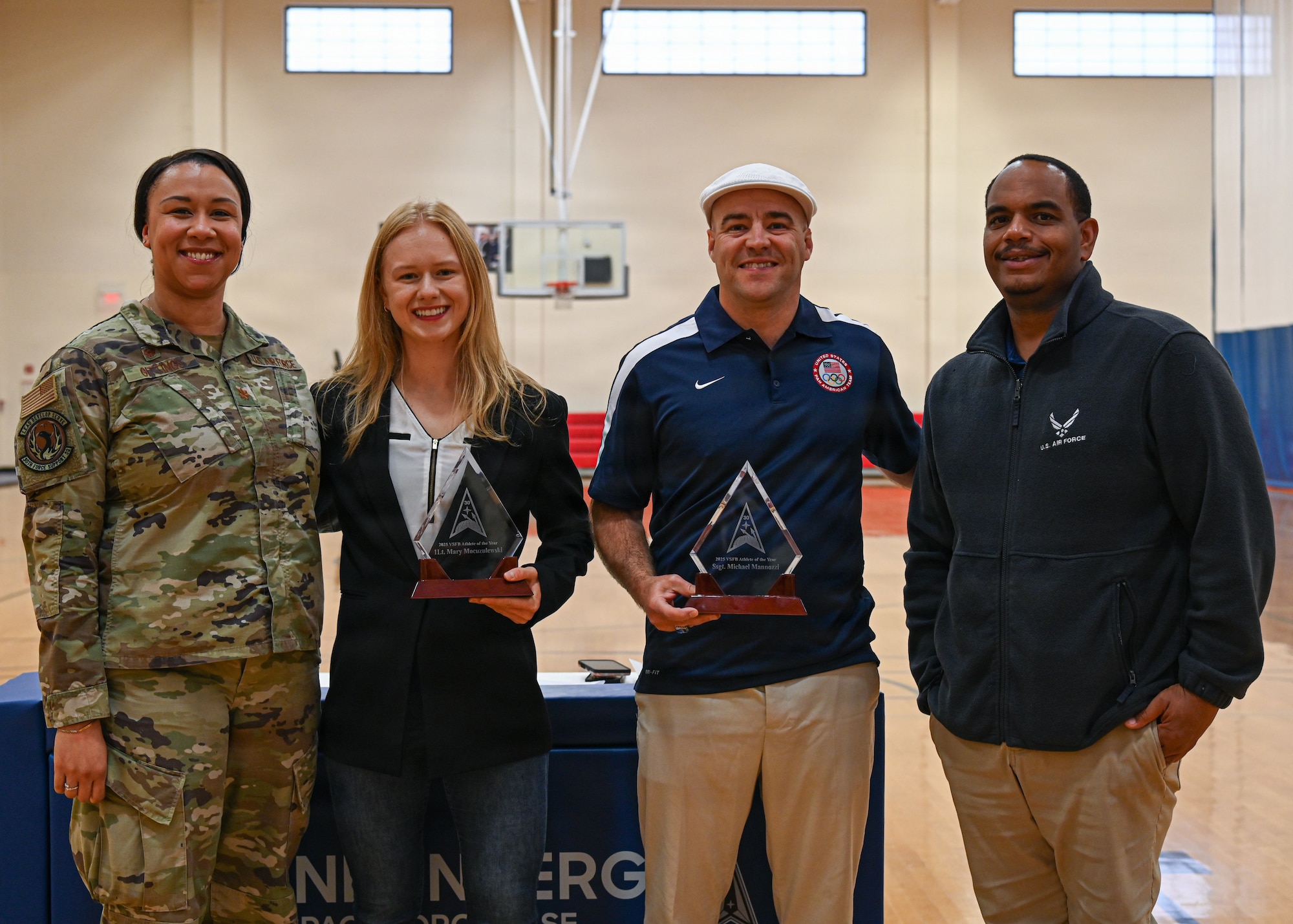Vandenberg's 2025 male and female athletes of the year pose for a photo with 30 FSS leadership with their new awards.