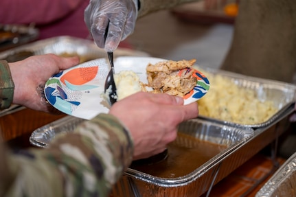 An Airman places food on the plate of another Airman during a Thanksgiving lunch at Joint Base Anacostia-Bolling, Washington, D.C., Nov. 26, 2025. 11th Wing leadership served a Thanksgiving meal to single JBAB service members as an appreciation to defending our country’s security throughout the year. (U.S. Air Force photo by Hayden Hallman)