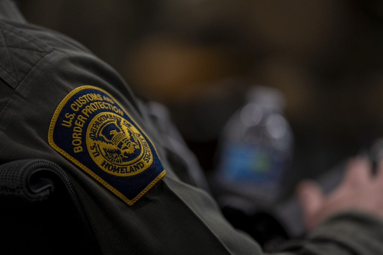 A close-up view of a patch on the arm of a service member reads "U.S. Customs and Border Protection."