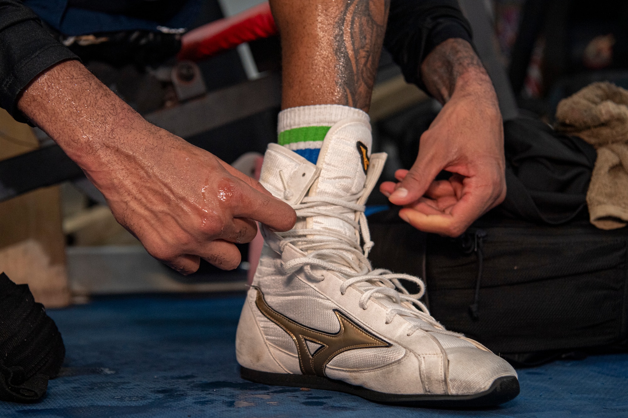U.S. Air Force Senior Airman Craig Jeudy, Fifth Air Force technical support technician, unlaces his shoes after a training session