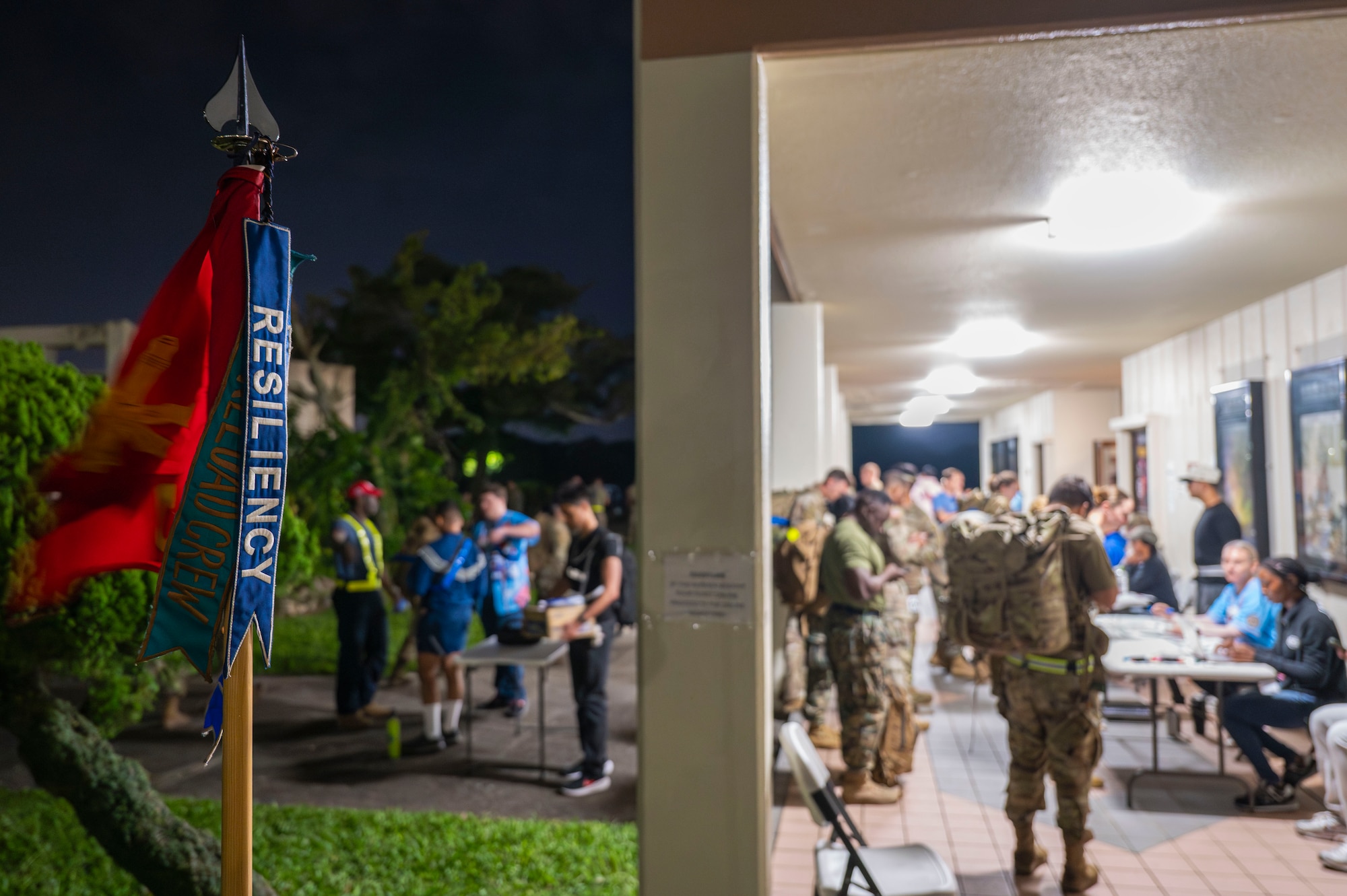 A guidon stands near the Keystone Theater as U.S. service members sign up for the Norwegian Foot March at Kadena Air Base, Japan, Nov. 22, 2025.