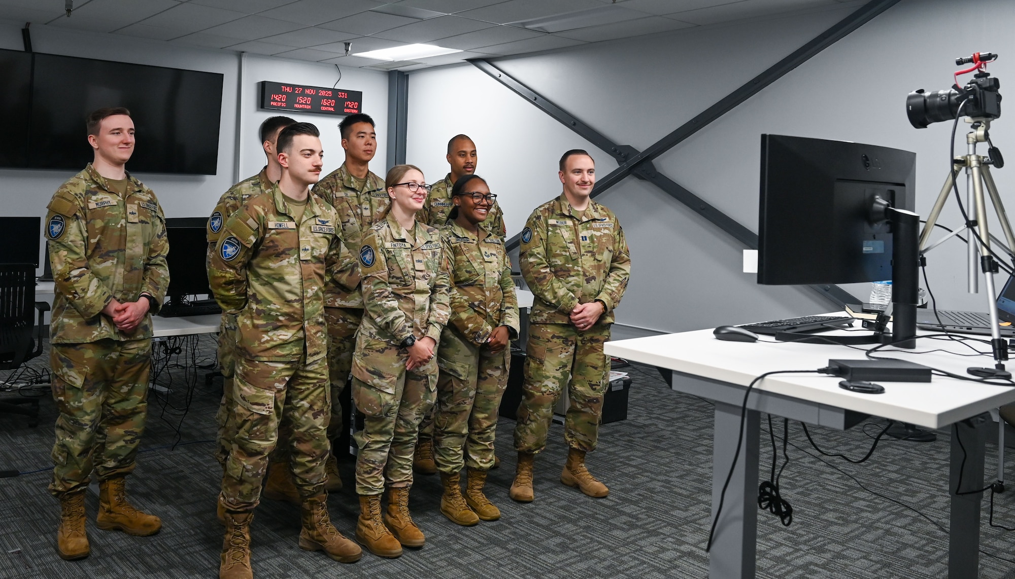 U.S. Space Force Capt. Ryan Weber, 18th Space Defense Squadron mission director, stands with his team and watch the screen as they are recognized by U.S. President Donald J. Trump during a virtual meeting.