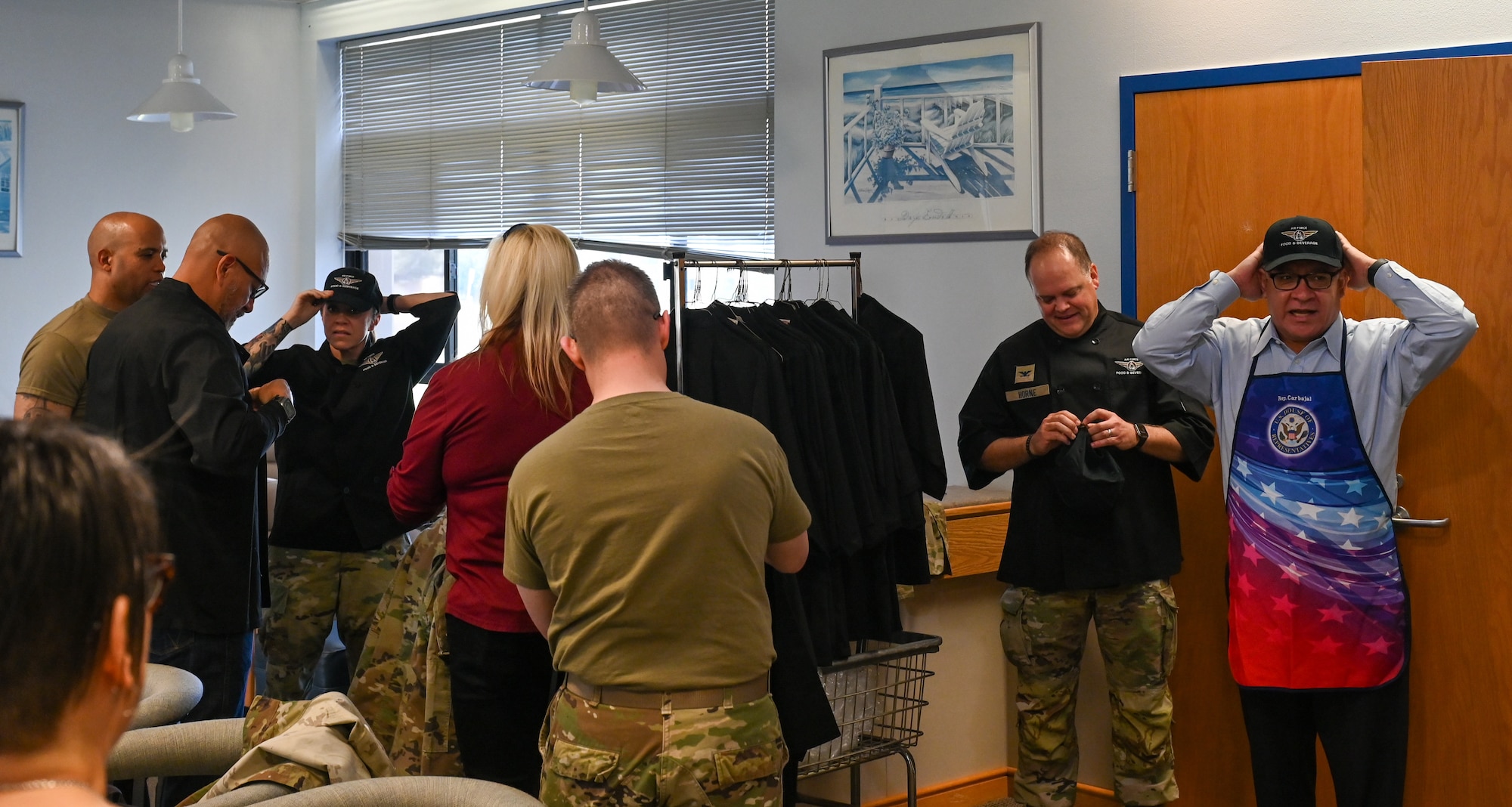 U.S. Congressman Salud Carbajal (D-24th/CA) and Space Launch Delta 30 leadership prepare by putting on kitchen attire.
