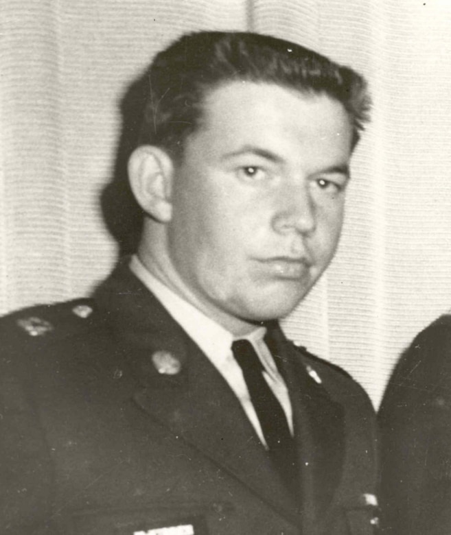 A man in a military dress uniform looks stoic for a photo.