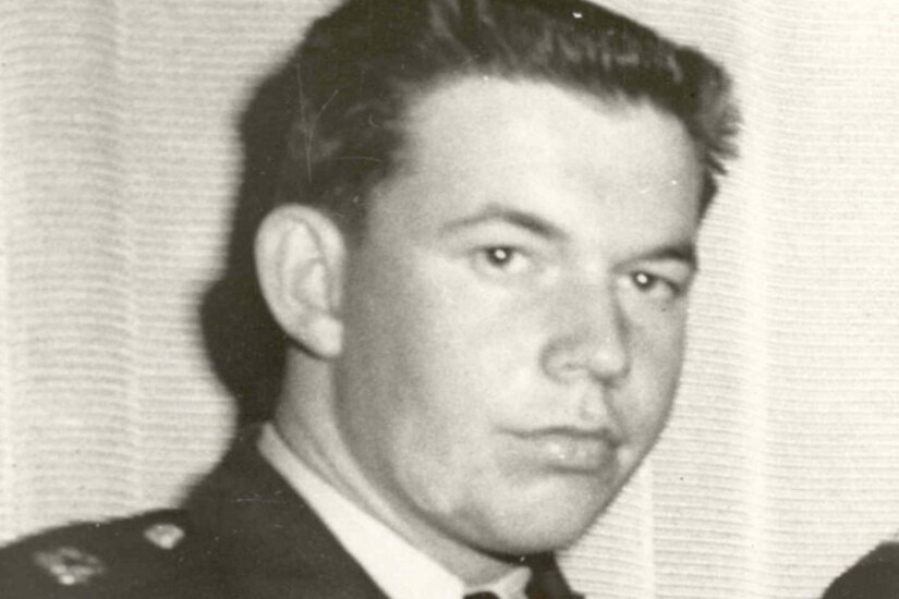 A man in a military dress uniform looks stoic for a photo.