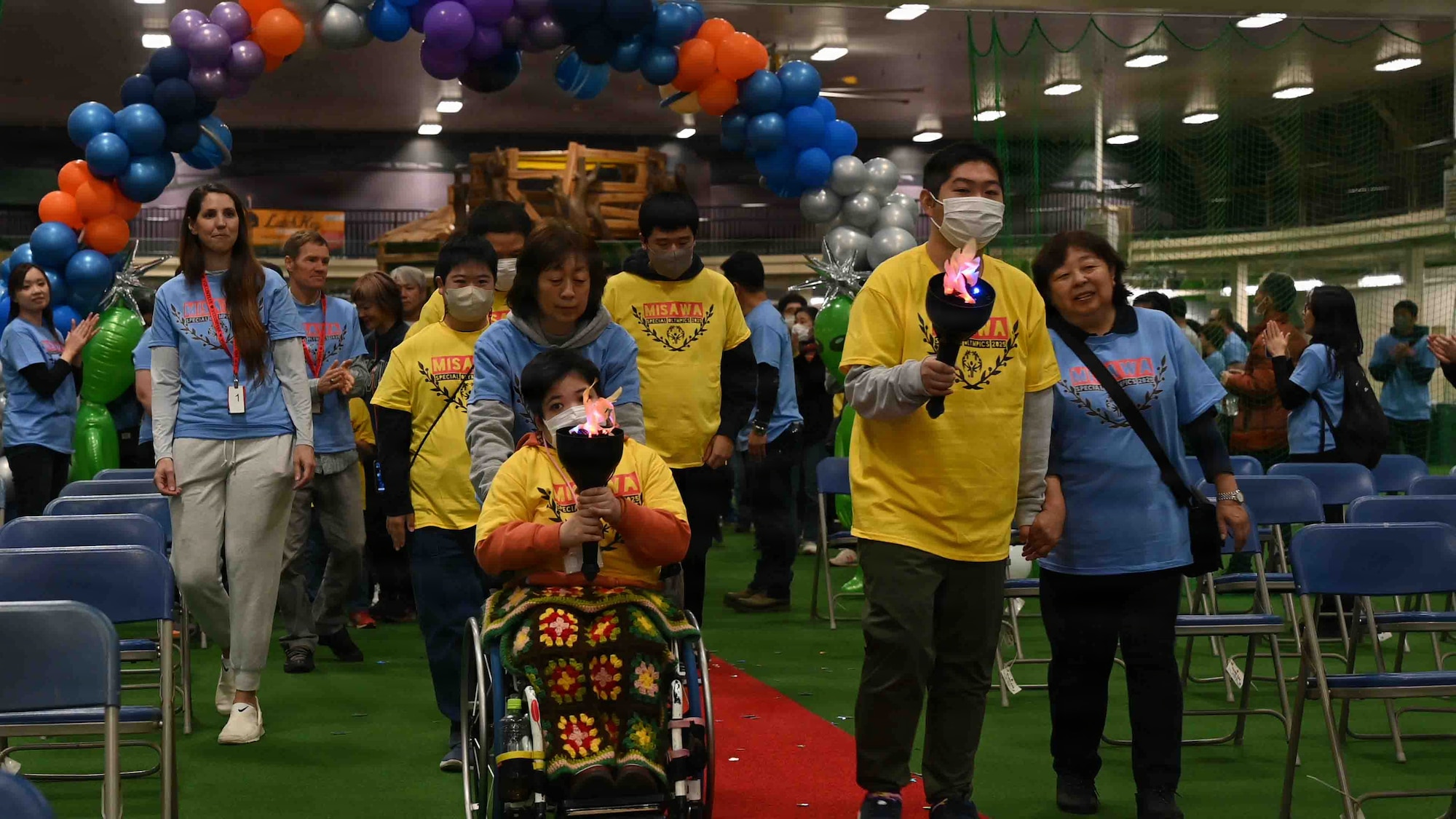 Participants and volunteers prepare to light the torch during the Misawa Special Olympics 2025 opening ceremony at Misawa Air Base, Japan, Nov. 15, 2025. The lighting of the torch signifies the start of the event, which brings together both base and local community members. (U.S. Air Force photo by Airman 1st Class Adryan Young)