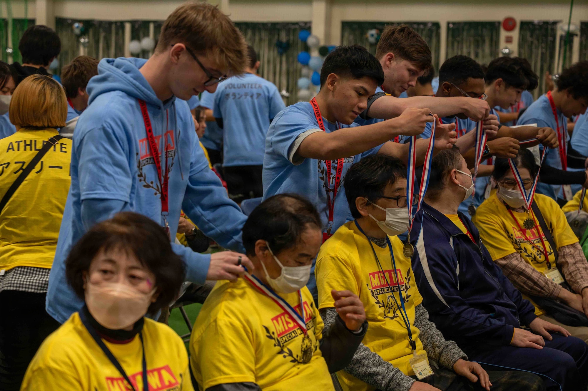 Volunteers give medals to the participants of the Misawa Special Olympics 2025 event at Misawa Air Base, Japan, Nov. 15, 2025. The annual event brought together both base and local community members for a day full of games and celebration. (U.S. Air Force photo by Airman 1st Class Adryan Young)