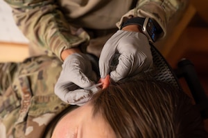 A U.S. Airman performs battlefield acupuncture on another U.S. Airman