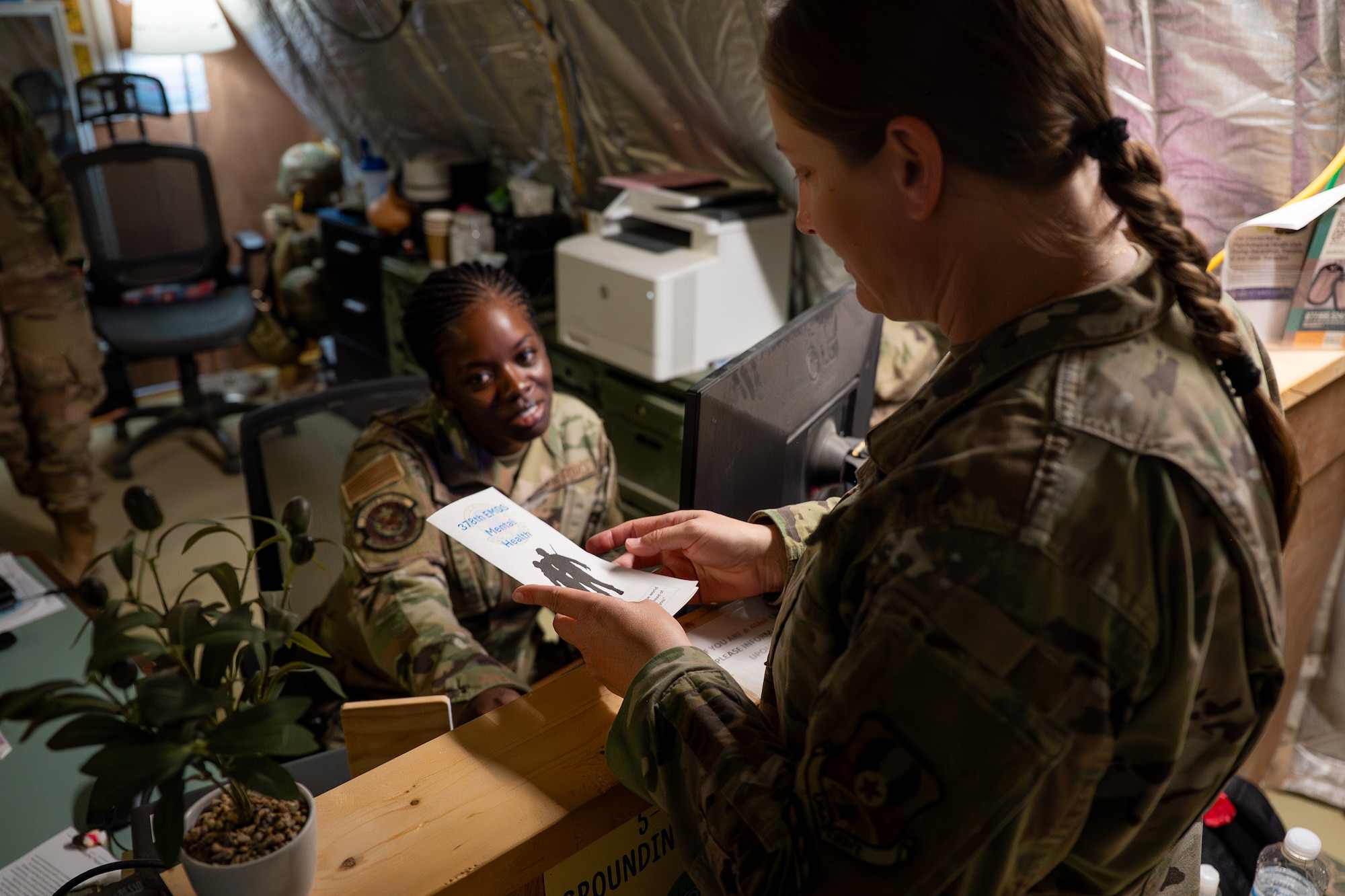 Two U.S. Airman read a mental health brochure