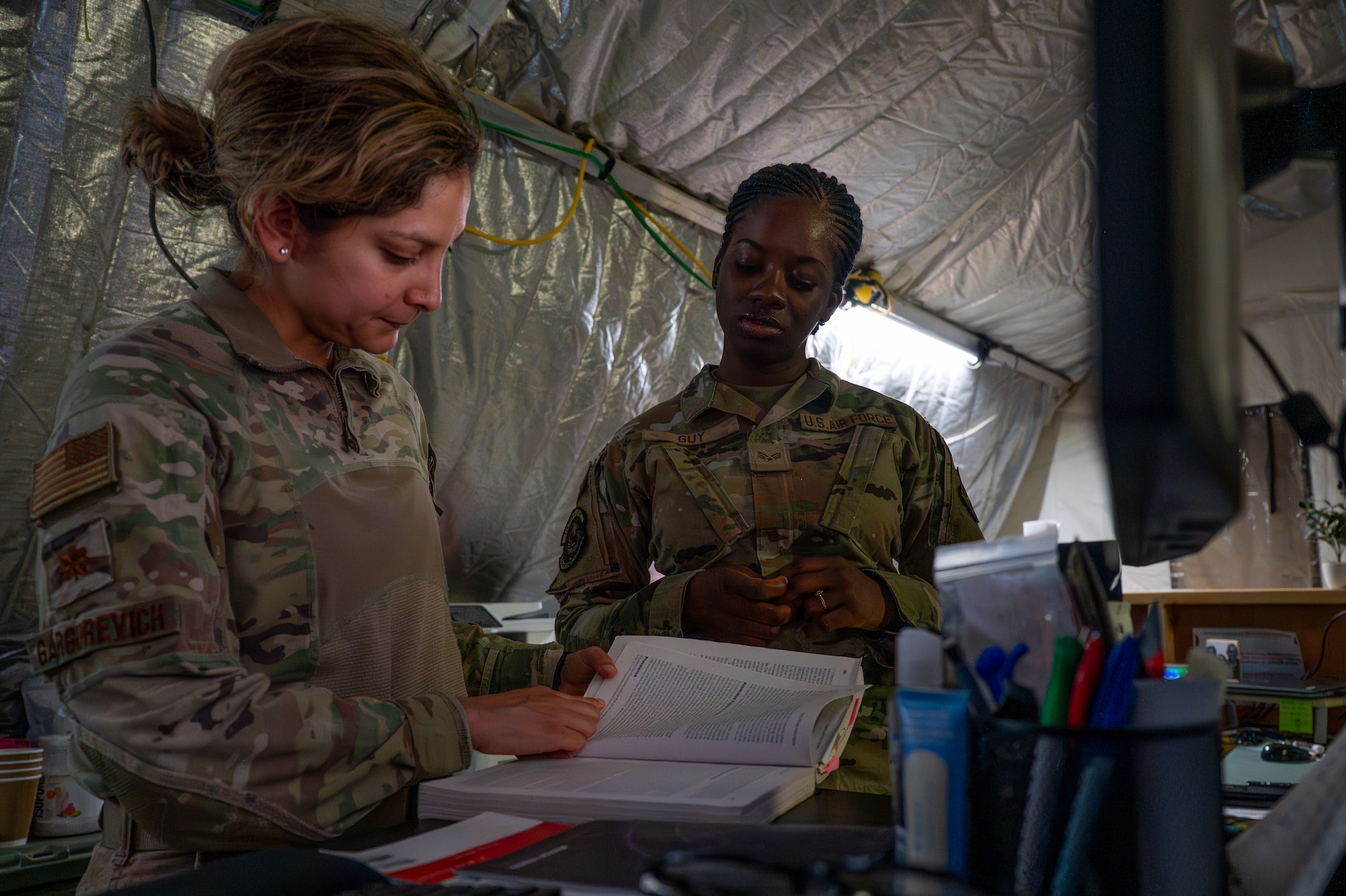 Two U.S. Airmen read from a mental health book
