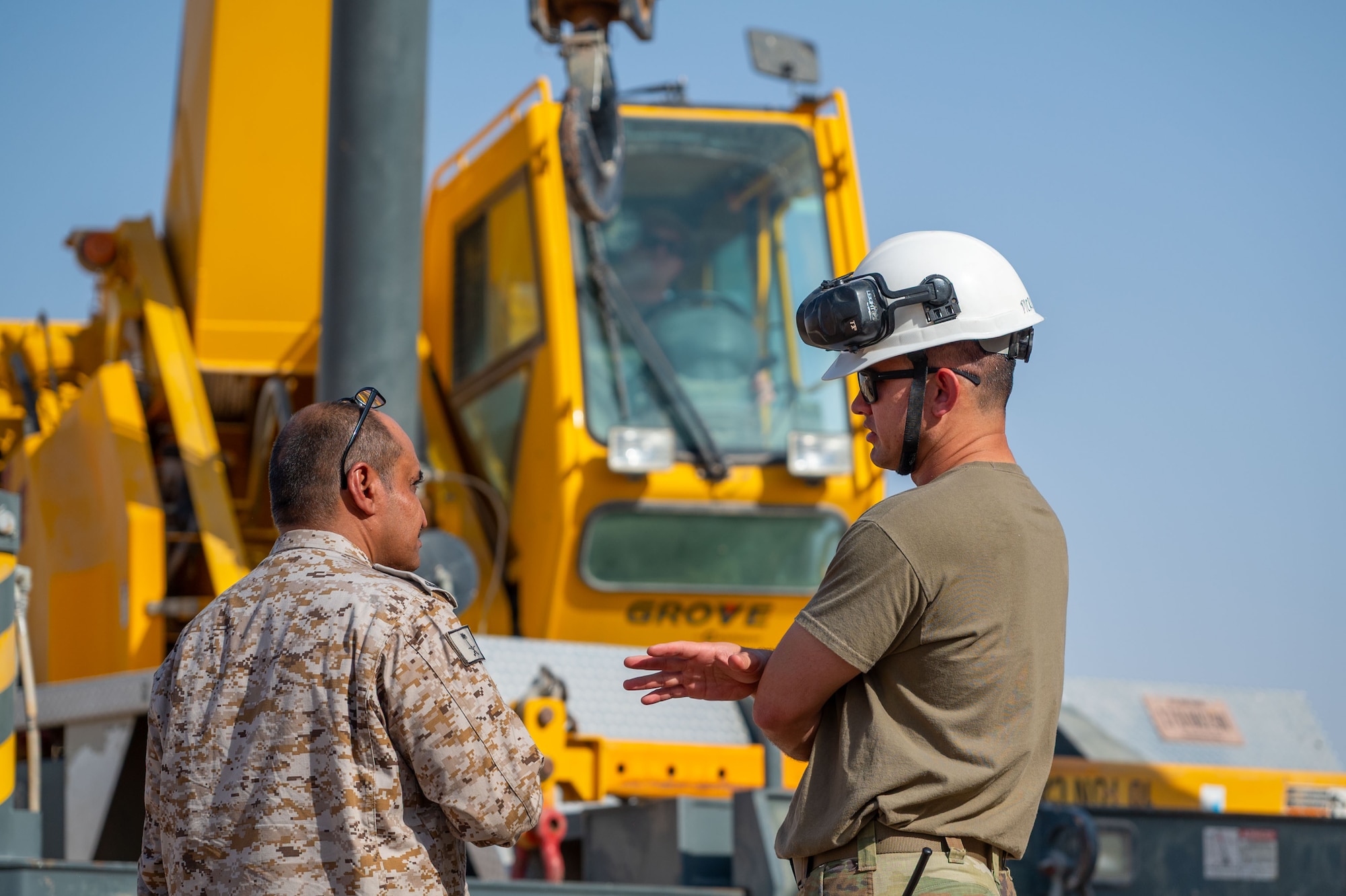 Right, U.S. Air Force Master Sgt. Patrick McParlane, 378th Expeditionary Maintenance Squadron flight chief, discusses operations with a Royal Saudi Air Force service member during a Crash, Damaged, Disabled, Aircraft Recovery exercise.