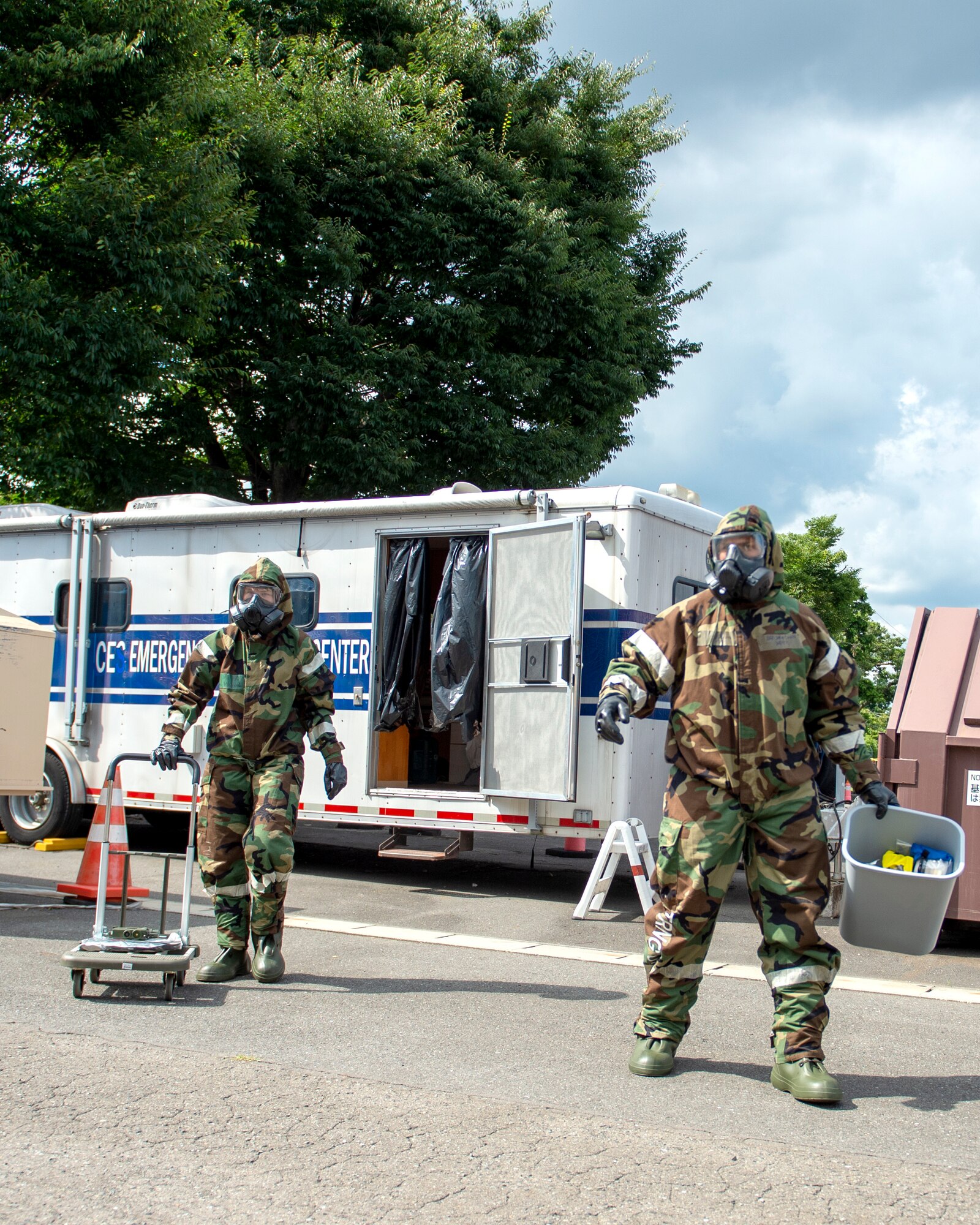 U.S. Air Force Airman 1st Class Skylar McDonald and Tech. Sgt. Jared Smith, 133rd Emergency Management, transport samples from a simulated illicit drug lab on Yokota Air Force Base, Japan, July 07, 2022.