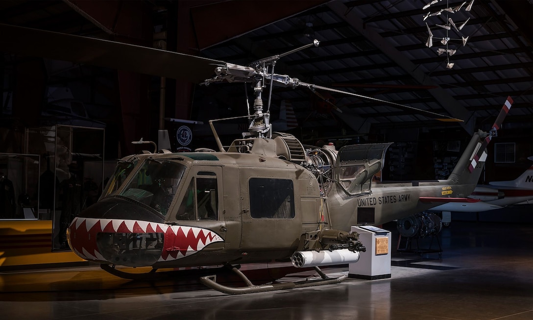 A helicopter and other aviation equipment are on display in a large building.