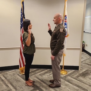 CPT Chris Cooper administers the Oath of Office to CPT Claudia Carrazco