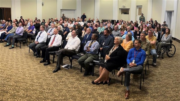 A group of people are seated in an auditorium.