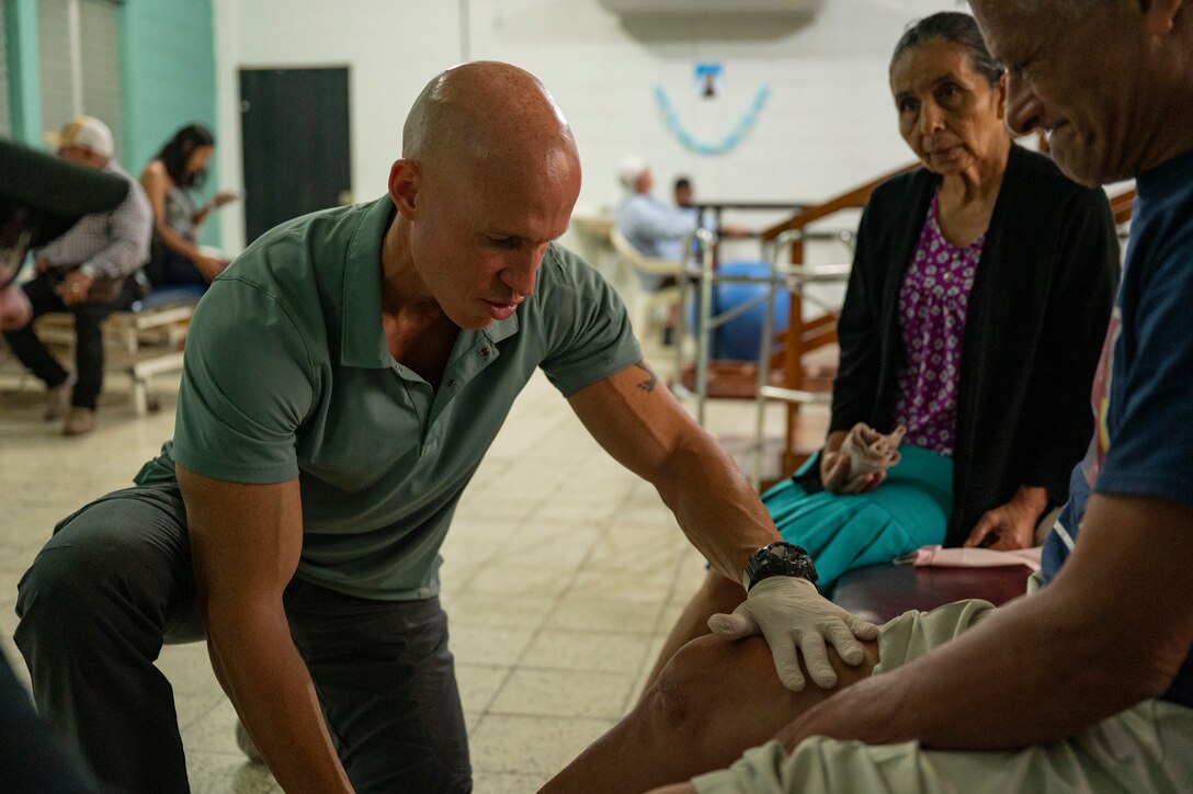 U.S. Army Reserve Maj. Collier Amundson, left, Army Forces Medical Detachment Chief of Rehabilitation, examines a La Paz Honduran local, Rito Chevez’leg during a physical therapy exercise at Centro de Rehabilitacion Integral de Comayagua, Comayagua, Honduras, Sept. 17, 2025. Amundson works alongside local physical therapists to provide quality care to patients while building and strengthening their partnership through knowledge exchanges. (U.S. Air Force photo by Staff Sgt. Sadie Colbert)