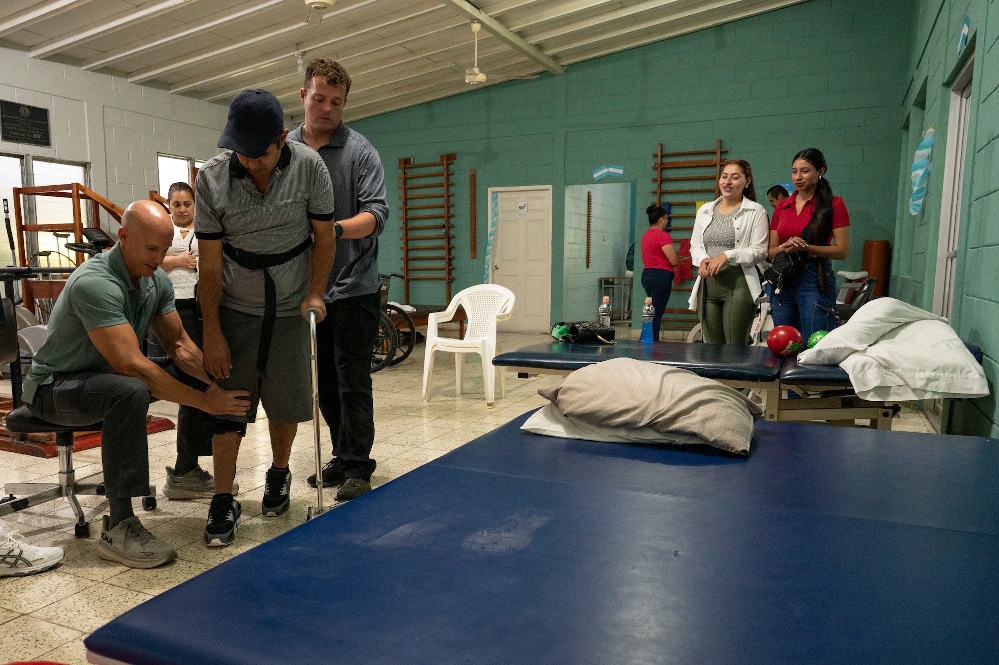 U.S. Army Reserve Maj. Collier Amundson, left, Army Forces Medical Detachment (AFMD) Chief of Rehabilitation, helps Euceda, center-left, walk, while U.S. Army Reserve Sgt. Tyler Grant, center, AFMD Combat Medic and Physical Therapy Assistant, stabilizes him, while his family watches at Centro de Rehabilitacion Integral de Comayagua, Comayagua, Honduras, Sept. 17, 2025. Amundson helped Euceda recover his mobility to be able to walk and speak after experiencing a stroke. For over forty years, Joint Task Force-Bravo’s medical missions have delivered essential healthcare services to remote and underserved populations, ensuring vulnerable communities receive medical care they might otherwise lack due to limitations. (U.S. Air Force photo by Staff Sgt. Sadie Colbert)