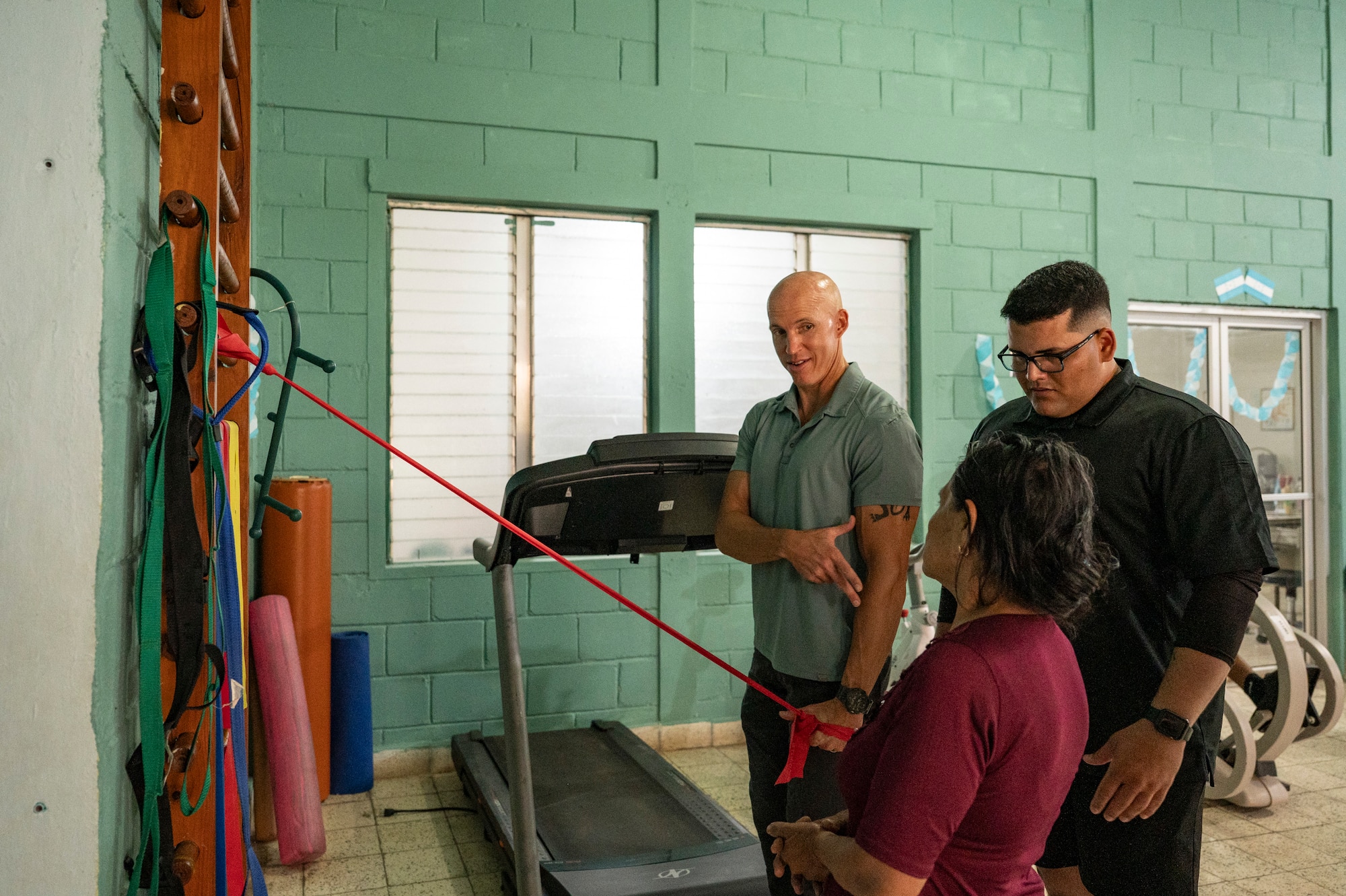 U.S. Army Reserve Maj. Collier Amundson, left, Army Forces Medical Detachment Chief of Rehabilitation, and Cpl. Jose Acevedo, Army Forces Battalion Military Police, explain steps for a strengthening exercise to Juana Vasquez Gonzalez, a Comayagua local, at Centro de Rehabilitacion Integral de Comayagua, Comayagua, Honduras, Sept. 17, 2025. After one session with Amundson, Gonzalez was able to raise her arm above her head, which she could not accomplish before seeing the physical therapist. Joint Task Force-Bravo medical providers, like Amundson, routinely conduct local medical missions, providing an opportunity for service members to engage with the local community and improve regional stability. (U.S. Air Force photo by Staff Sgt. Sadie Colbert)