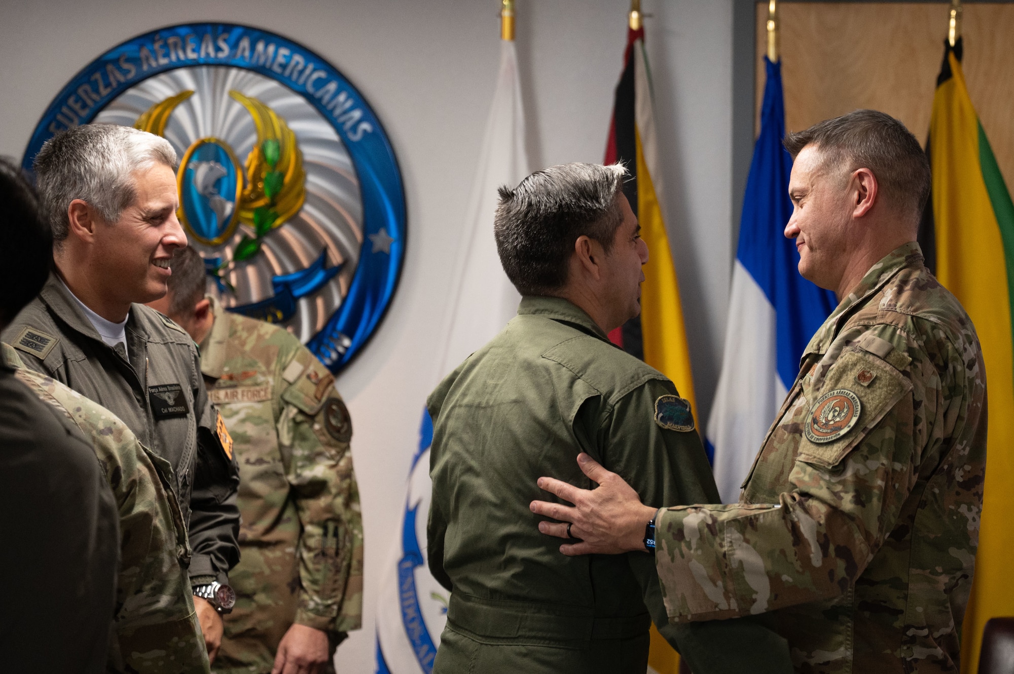 U.S. Air Force Col. David McIllece, outgoing secretary general of the System of Cooperation Among the American Air Forces, greets members after a change of responsibility ceremony at Davis-Monthan Air Force Base, Arizona, Oct. 1, 2025. SICOFAA is a voluntary organization within the U.S. Air Force whose main functions are humanitarian aid and airspace control. (U.S. Air Force photo by Airman Jaden Kidd)